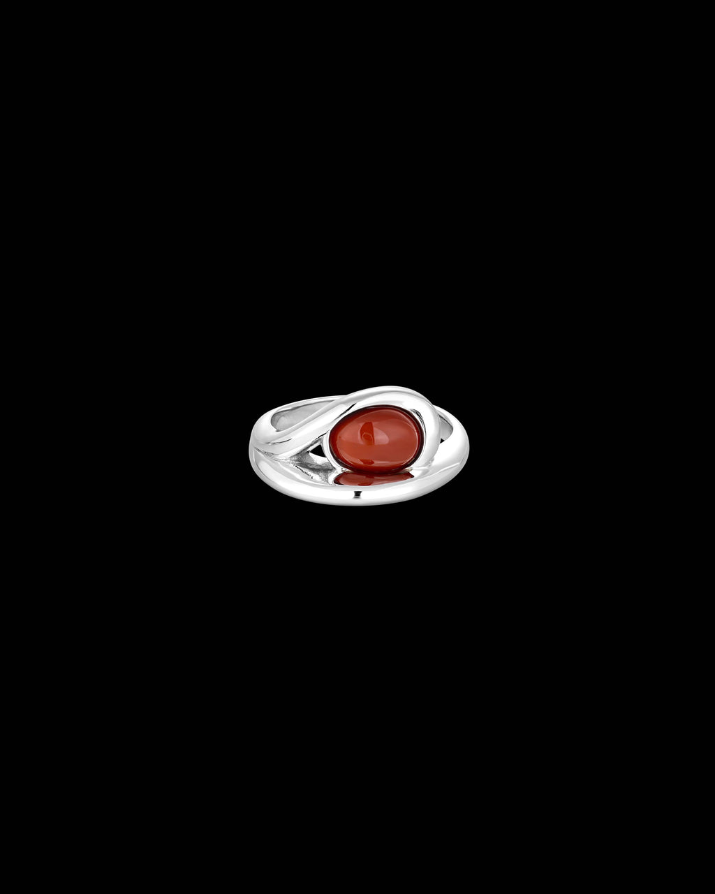A silver ring with a polished oval red cabochon gemstone, centered against a solid black background.